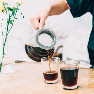Frisch gebrühter Kaffee wird aus einem Hario Range Server in ein Glas eingeschenkt.