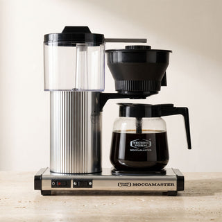 Moccamaster CD Grand auf Küchenarbeitsplatte, Filterkaffeemaschine in Edelstahl mit Glaskanne, frisch gebrühter Kaffee läuft durch