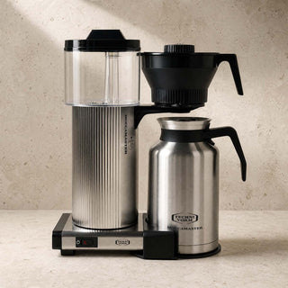 Moccamaster CDT Grand in Edelstahl mit Thermoskanne, Filterkaffeemaschine auf heller Steinfläche