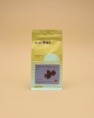 AMORI Coffee Café del Futuro, entkoffeinierter Farmkaffee aus Peru mit 100 % Arabica, in gelber Kaffeeverpackung mit hellblauen Streifen, lilafarbenem Etikett und dunkelbraunem geometrischem Symbol.