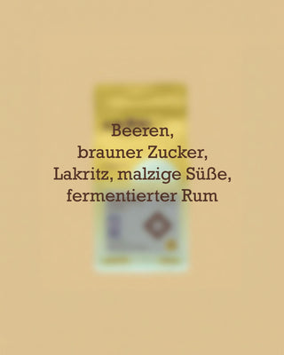 Geschmacksprofil des entkoffeinierten AMORI Nasa We’sx Kaffees aus Kolumbien mit den Aromanoten Beeren, brauner Zucker, Lakritz, malzige Süße und fermentierter Rum vor einer unscharfen Kaffeeverpackung.