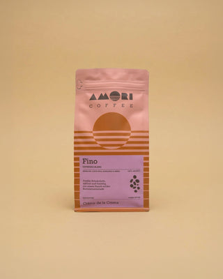 AMORI Coffee Fino Espresso-Blend aus 100 % Arabica in rosa-orangefarbener Kaffeeverpackung mit violettem Etikett und Herkunftsländern Brasilien, Costa Rica, Honduras und Indien.
