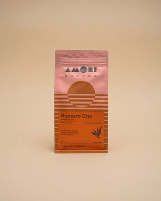 AMORI Coffee Numero Uno Espresso-Blend in einer rosa-orangefarbenen Kaffeeverpackung mit orangefarbenem Etikett, 80 % Arabica und 20 % Robusta.