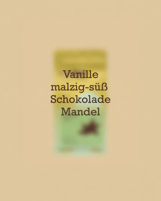Geschmacksprofil des AMORI Kiyumba Farmkaffees aus Ruanda mit den Aromanoten Vanille, malzig-süß, Schokolade und Mandel vor einer unscharfen Kaffeeverpackung.