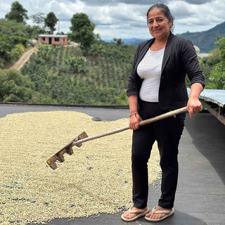 Mary Luz Ruiz auf der El Placer Farm in Kolumbien beim Trocknen von Kaffeebohnen in der Sonne.