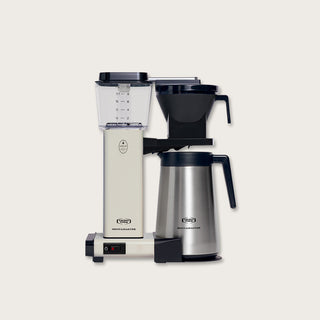 Frontansicht einer Moccamaster KBGT Filterkaffeemaschine in Off White mit Edelstahl-Thermokanne und transparentem Wassertank.