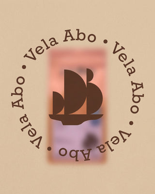 Unscharfe Vela-Kaffeepackung auf beigem Hintergrund mit Segelschiff-Symbol und kreisförmigem Schriftzug „Vela Abo“.